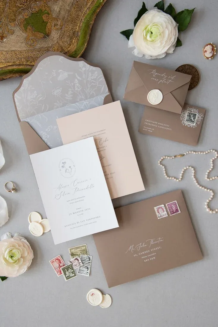 Partecipazione di matrimonio aperta con testo elegante e monogramma